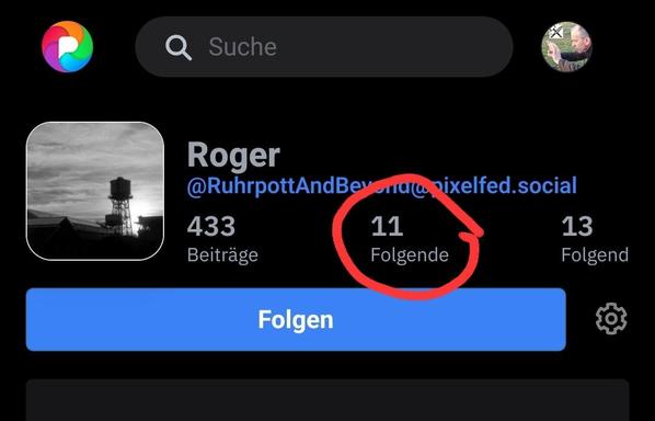Ein Screenshot eines Social-Media-Profils im Dunkelmodus. Oben befindet sich eine Suchleiste mit dem Text „Suche“ und einem farbigen Logo links. Das Profil zeigt ein quadratisches Schwarz-Weiß-Foto eines Wasserturms, den Namen „Roger“ und die Kennung „[@]RuhrpottAndBeyond[@]pixelfed.social“. Die Statistiken unter dem Namen sind „433 Beiträge“, „11 Folgende“ und „13 Folgend“, wobei der Text „11 Folgende“ von einem roten Kreis markiert ist. Darunter befindet sich eine große blaue Schaltfläche mit…