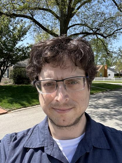 A photo of myself taken with my phone's selfie cam.

I am standing in the middle of a residential street in town having just left the stylist's. It is a beautifully clear and sunny day after meh weather. The lighting is still subdued because there are some lovely large trees in the neighborhood providing shade. It would be an ideal street to plan on (I guess we aren't supposed to do that anymore though)!

I am wearing a dark navy (not too saturated) button up shirt made from synthetic fabric. T…