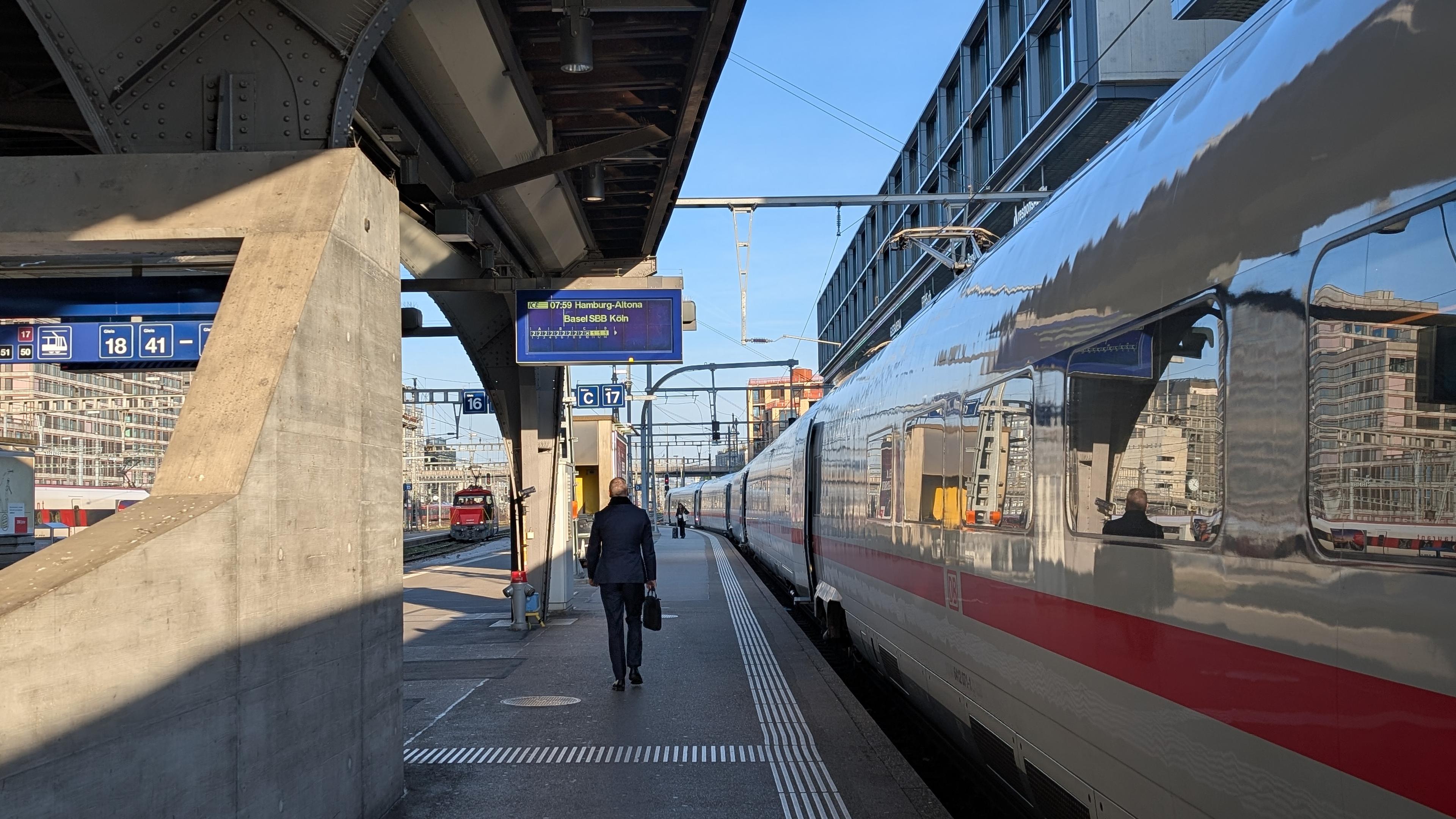 An ICE 4 at Zurich main station, platform display indicating ICE to Basel SBB, Köln and Hamburg-Altona at 7.59, sun partly alluminating the platform