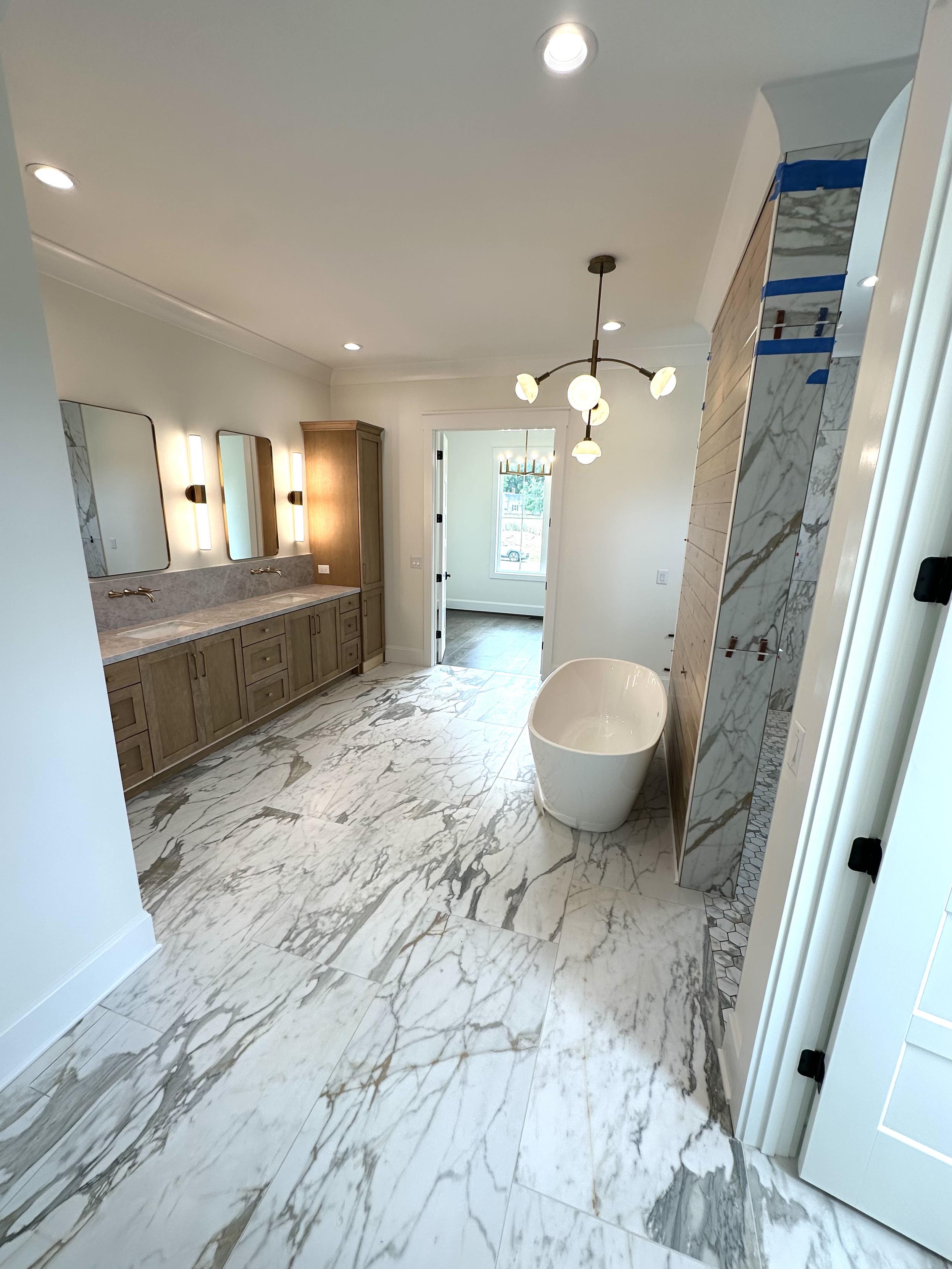 A huge master bath with marble floors.