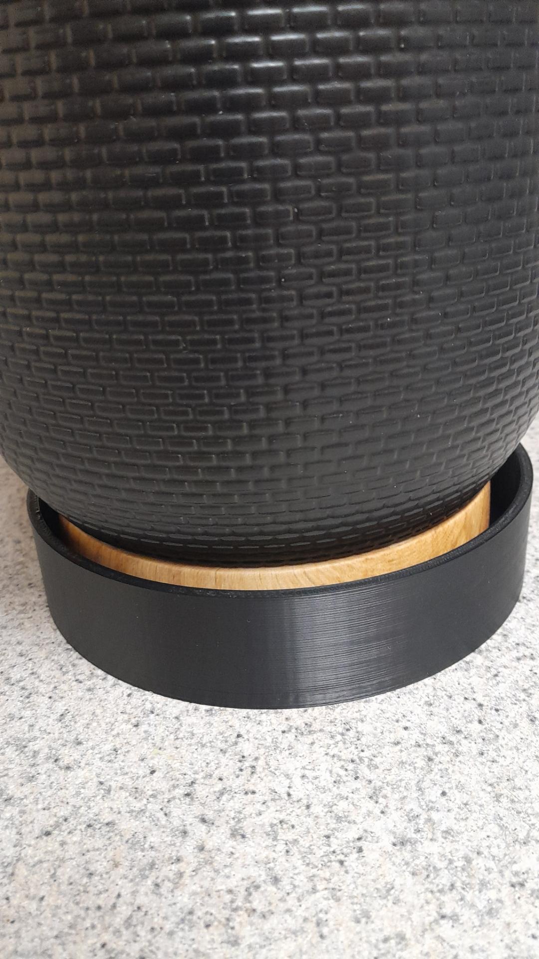 Close up of black planter pot on disk base