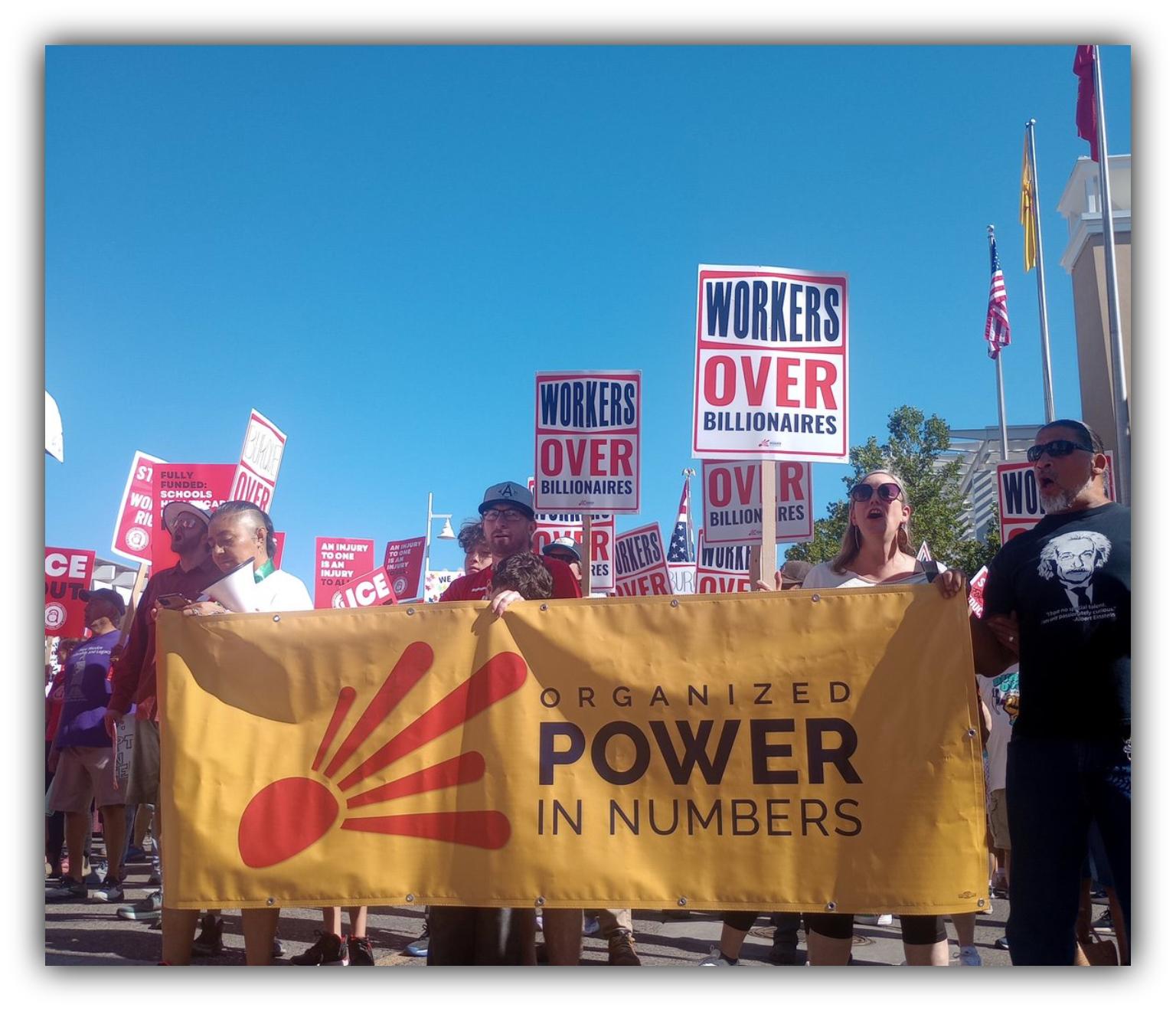 Close-up view of protest signage from a May Day rally associated with the “Workers Over Billionaires” movement. The signs reference labor rights, economic inequality, and political influence during coordinated demonstrations held across Alaska and the United States on May 1, with participants gathered for public action and marches.