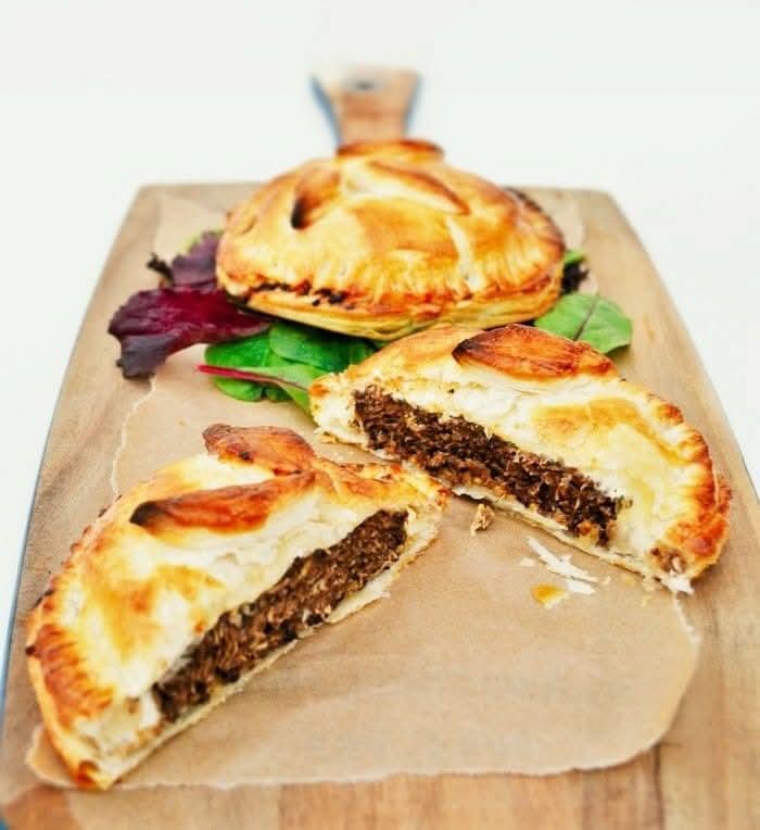 Golden puff pastry burger pies on a wooden board