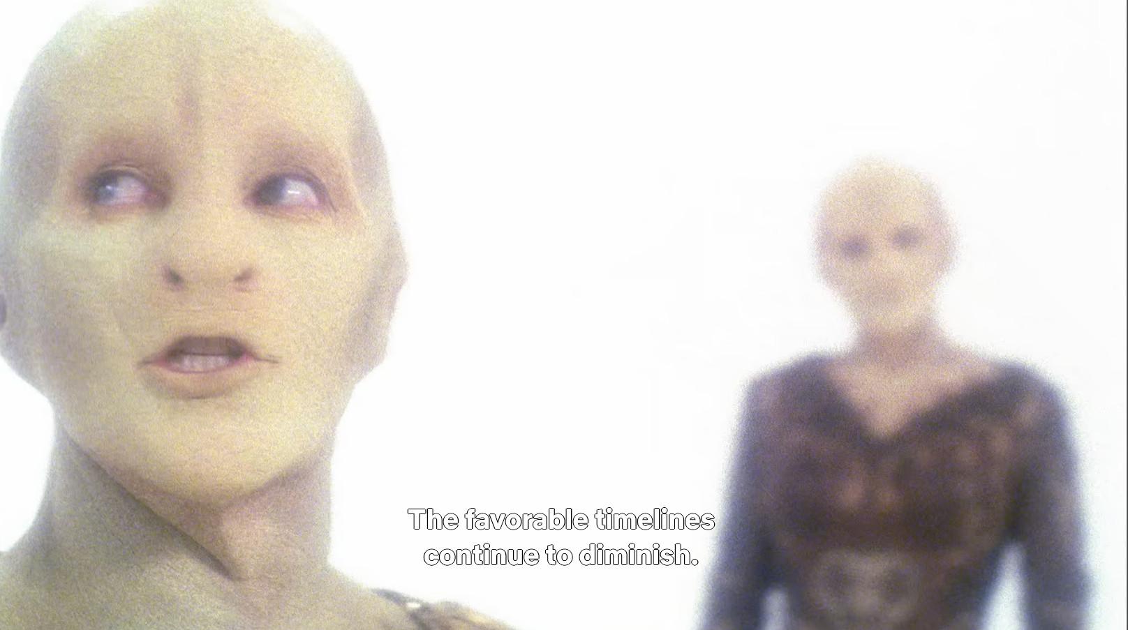 Star Trek Enterprise scene. 🎶ITS BEEN A LONG ROAD🎶 Ok, so, we're in one of those scenes where people are in a dreamlike state or maybe a liminal space between realities. Entirely white, misty foggy type backdrop, no other imagery or people or anything, just white. We see a scaley skinned flat snakey nose looking lady with no hair and some odd shaping to her noggin. (She's like a slightly reptilian humanoid alien lady) We see her in two views, soap opera style, one blurry in the background, and then her in focus face up close. Closed caption reads, "The favorable timelines continue to diminish."