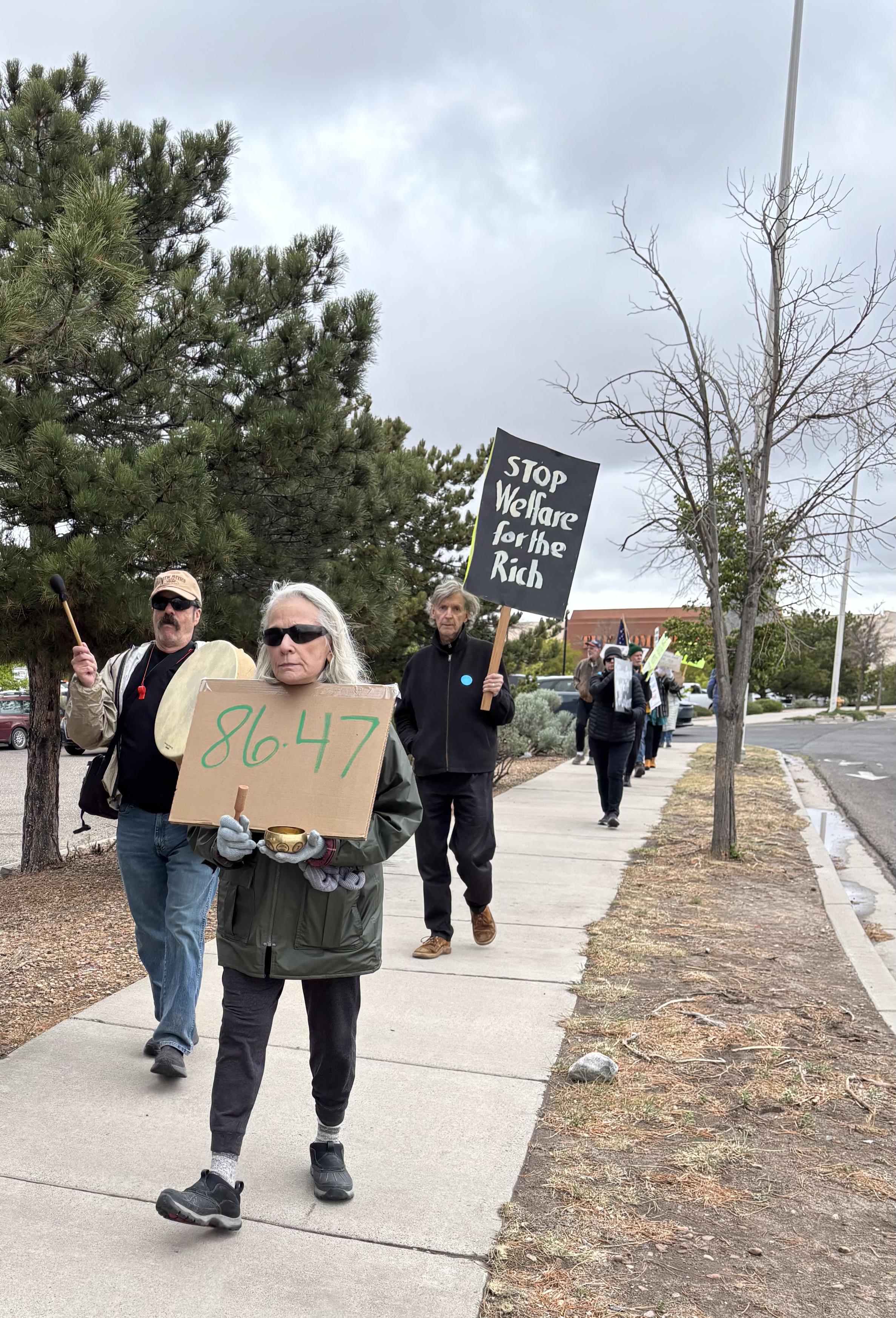 Woman with a sign reading 8647. Other marchers behind her.
