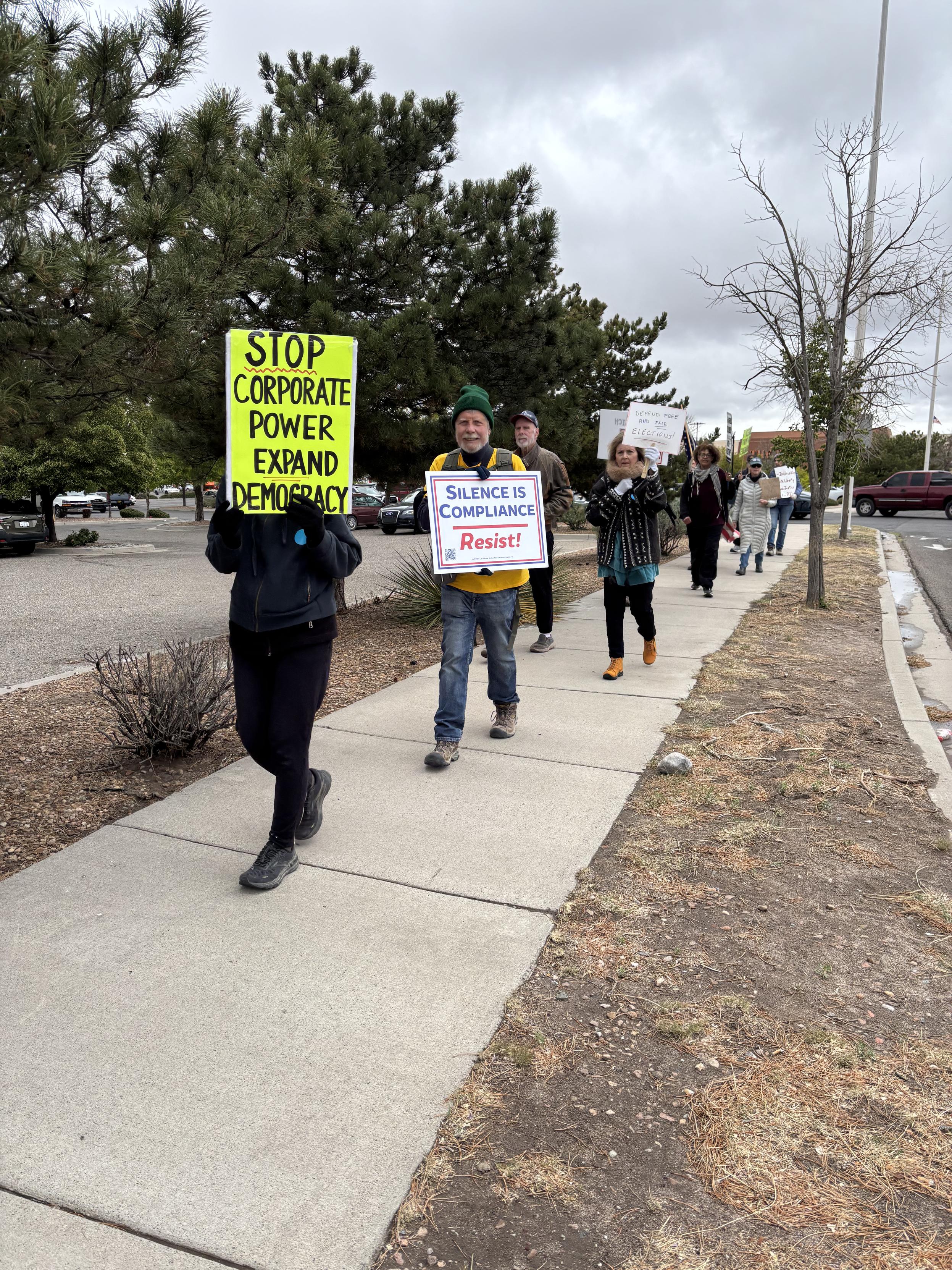 Marchers.  In front, person carrying sign reading Stop Corporate Power.