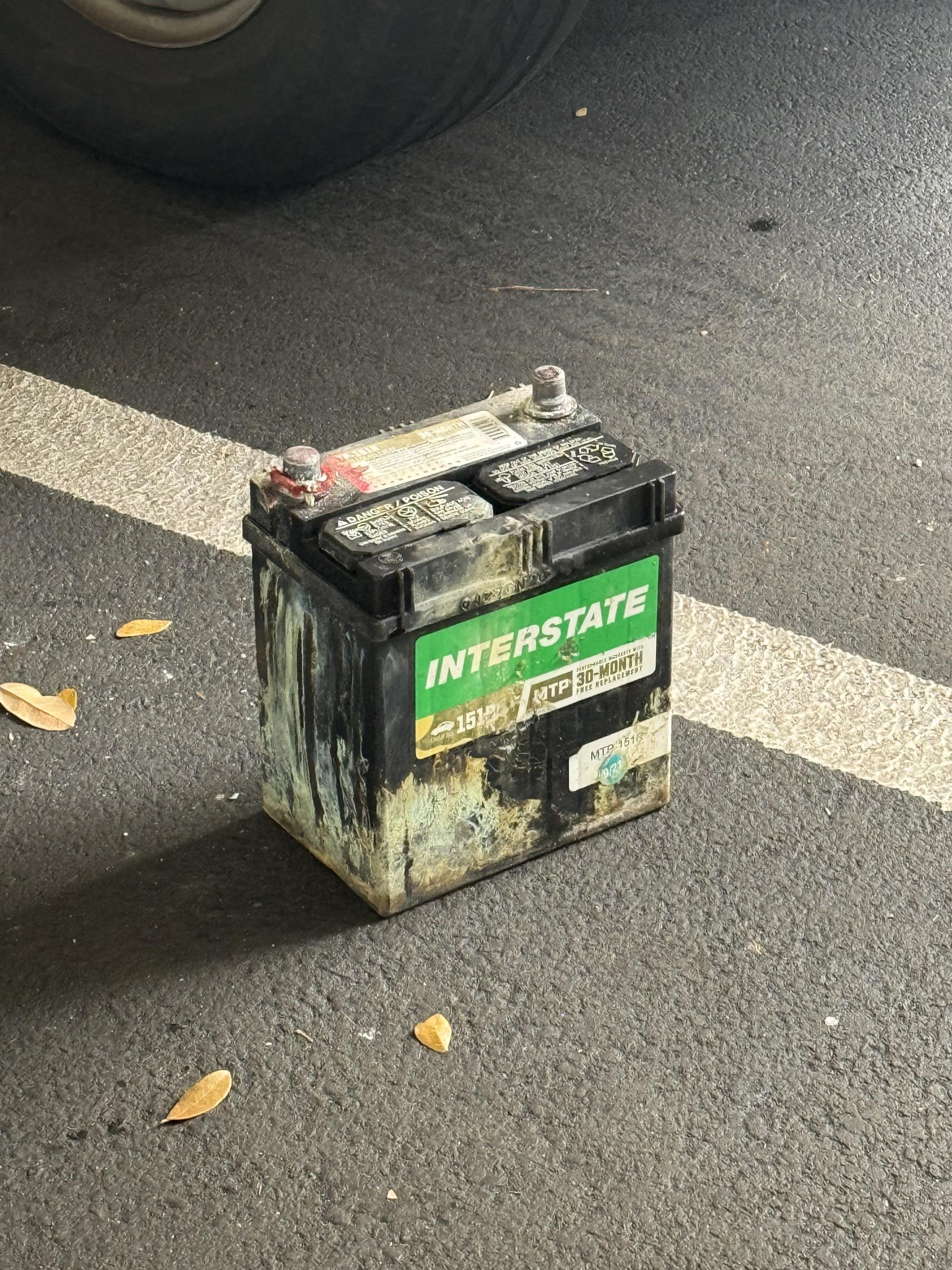My coroded car battery sitting on the parking garage floor.