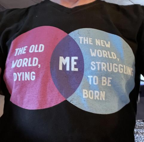 Picture of a black T-shirt which has two circle venn diagram
Left circle: “THE OLD WORLD, DYING”
Right circle: “THE NEW WORLD, STRUGGLING TO BE BORN”
Overlap in middle: “ME”