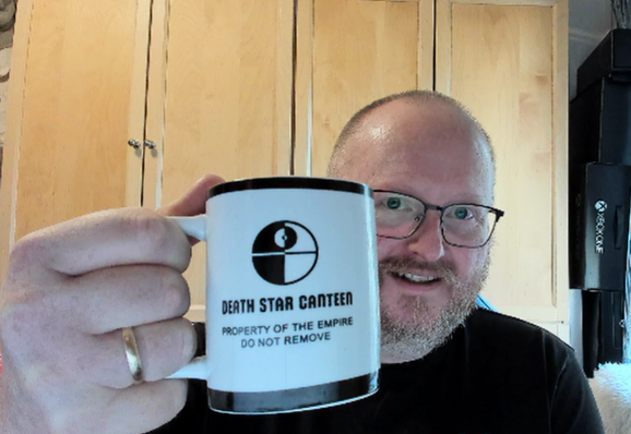 Person holding a coffee mug with a Death Star icon, and a large text saying
"DEATH STAR CANTEEN"
and two lines of smaller text beneath, stating
"PROPERTY OF THE EMPIRE"
"DO NOT REMOVE"