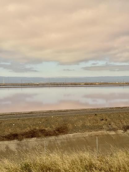Picture of San Francisco Bay with reflections of clouds in the still water.