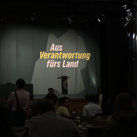 Bühne mit Backdrop mit dem Umriss von Baden-Württemberg und "Aus Verantwortung für das Land"