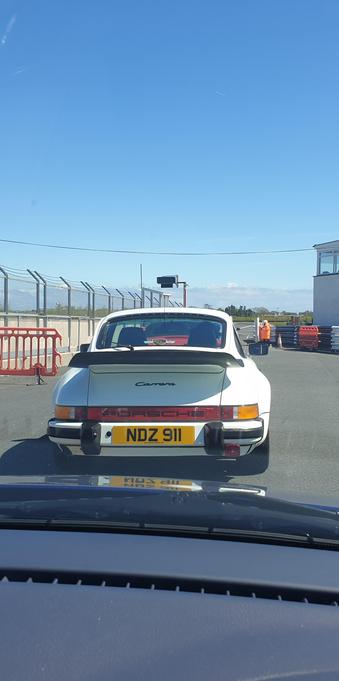 The rear of a white Porsche 911 SC, on a parade lap of the Kirkistown circuit in Northern Ireland.