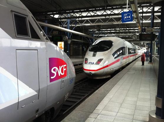 White ICE high-speed train with NS Dutch railways logo, silver grey TGV high-speed train with SNCF logo