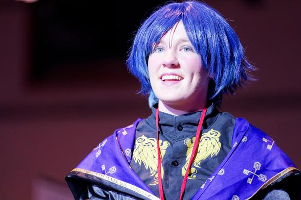 Woman with blue hair wig in something like a bob haircut with purple shawl