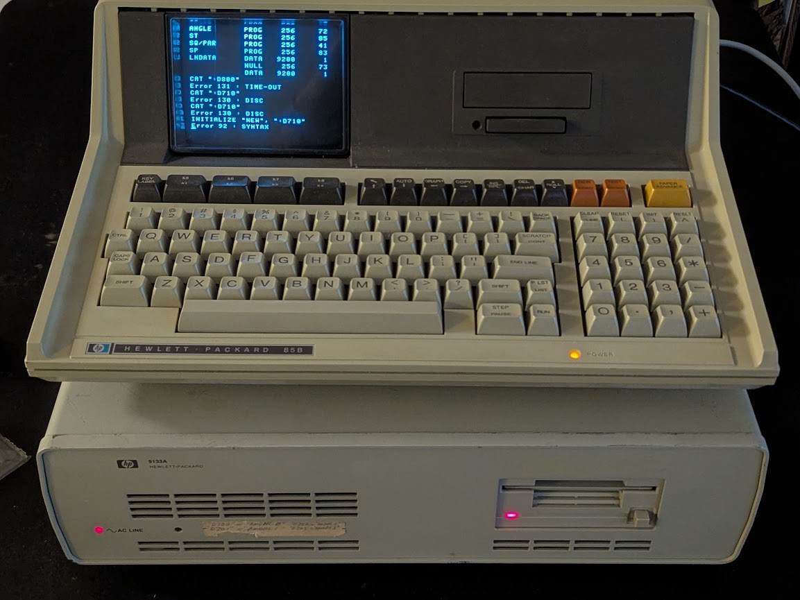 HP85/9133 stack with the INITIALIZE command running and the red access light for the floppy drive lit.