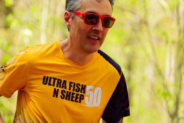 Man with yellow shirt with one black sleeve that reads ULTRA FIS N SHEEP 50
