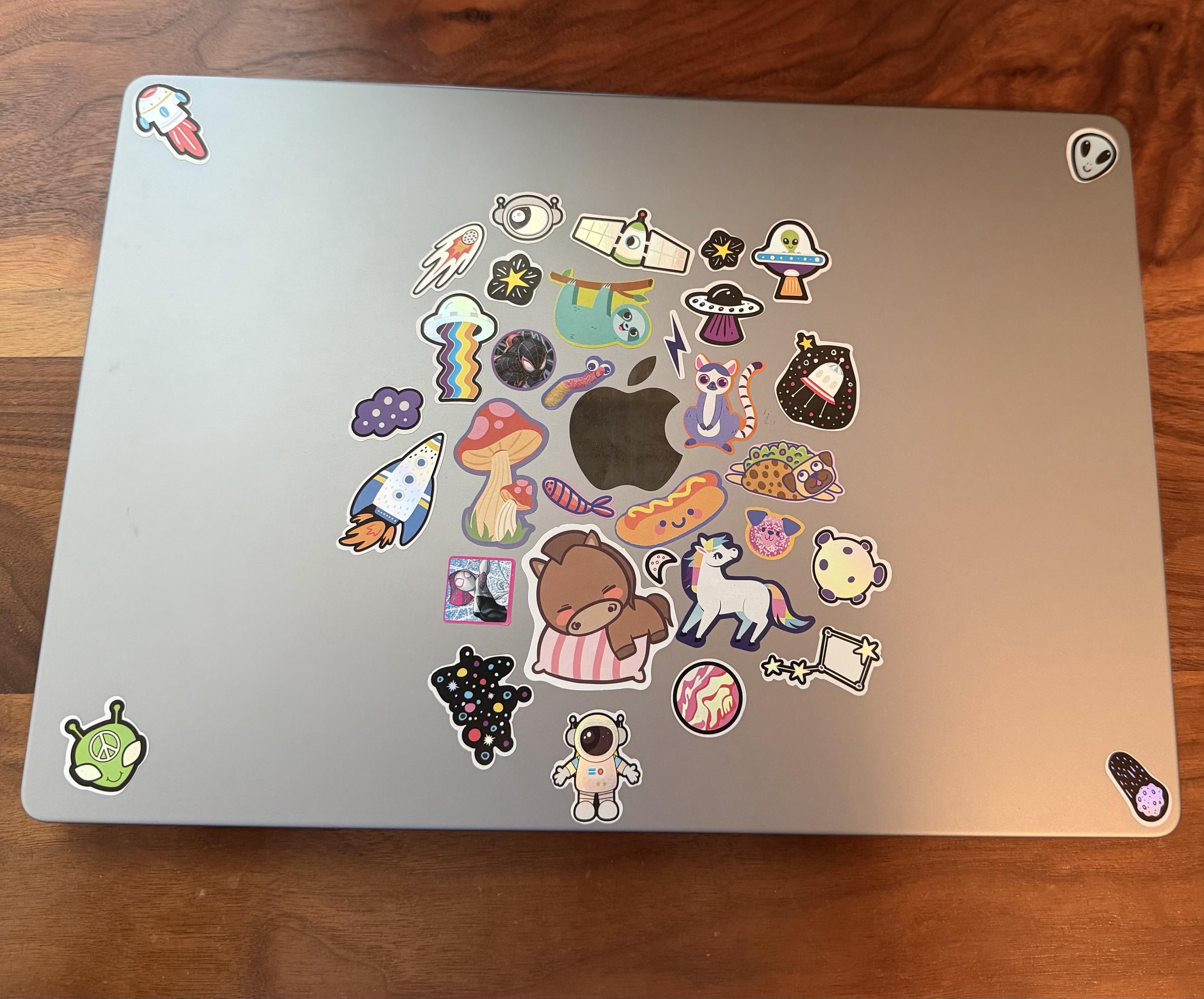 Photo of laptop MacBook with a bunch of colorful stickers on it that a child would have (a child did put these stickers on lol)