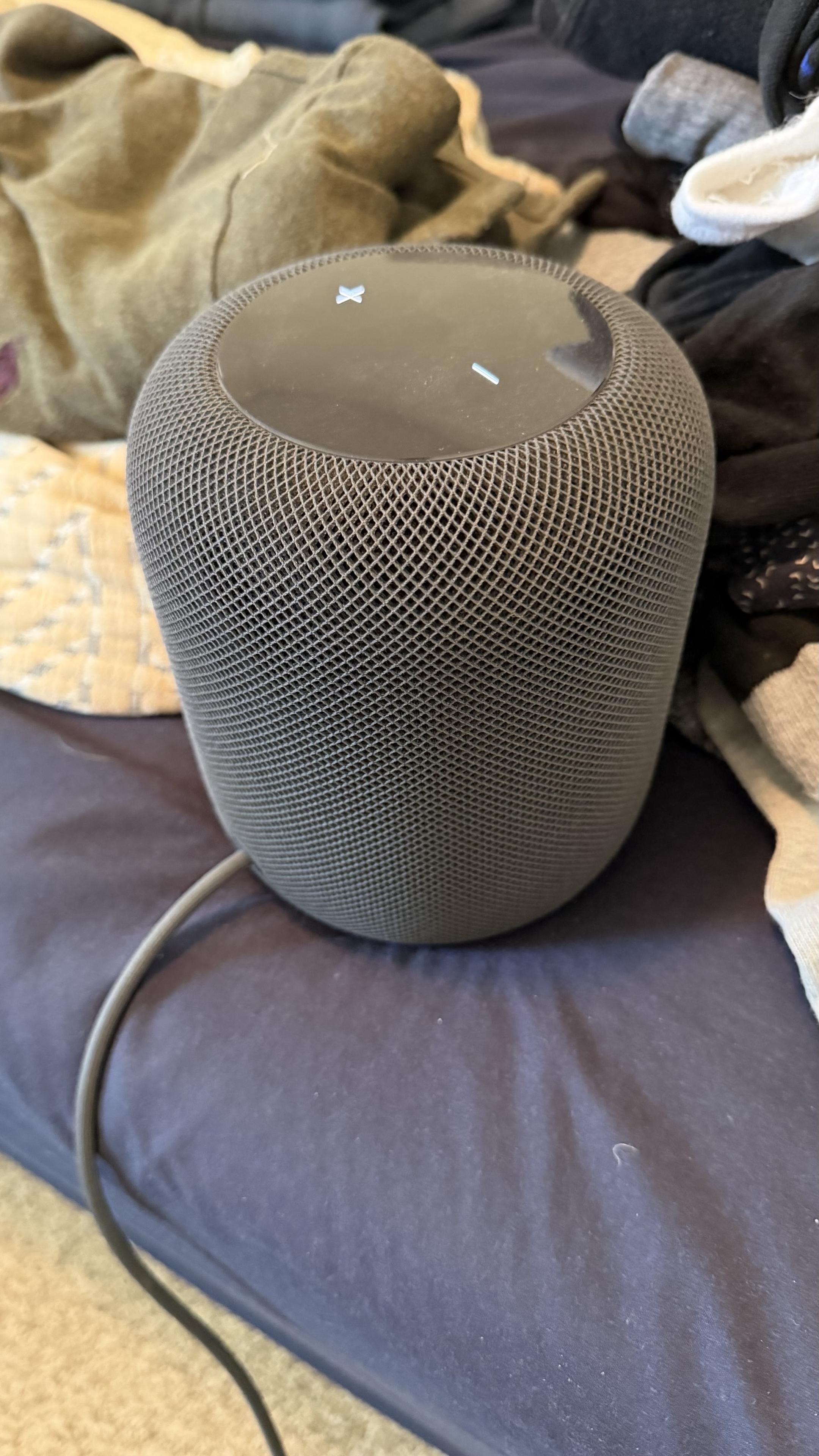 Photo of a black HomePod on a bed