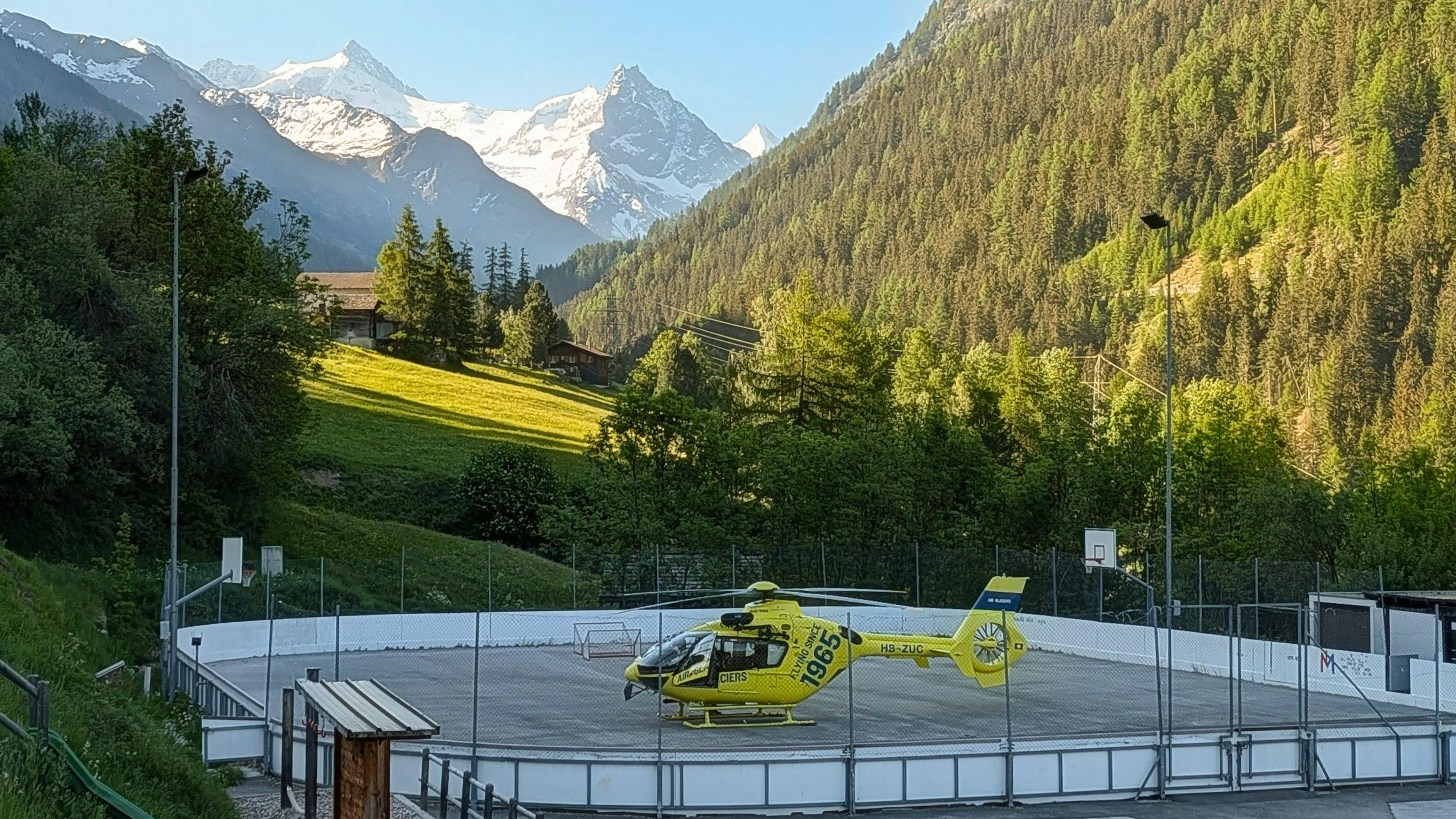 La patinoire Ayer Arena permet la pose des hélicoptères de sauvetage, ce qui n'est pas évident dans les villages de montagne. Il ne faut rien laisser qui puisse s'envoler alentours, et ranger les buts, merci les sportifs !