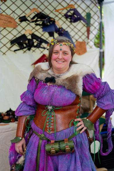 Smiling moan with purple dress and leather waist cincher and wrist cuffs