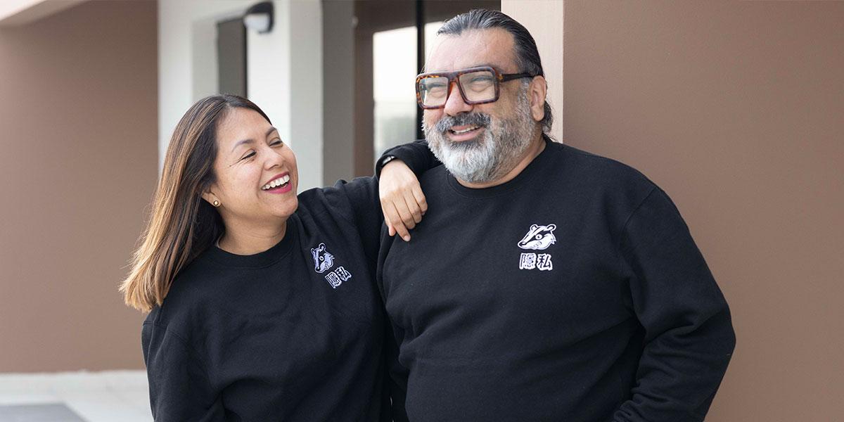 Two people wearing EFF's new Privacy Badger Crewneck. Features an embroidered Privacy Badger logo with Traditional Chinese characters that say "privacy."
