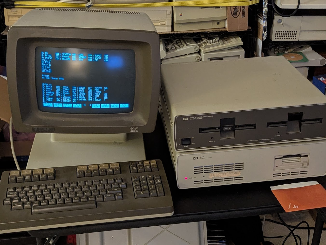 beige computer with brown fascia and bezels along with a keyboard and two large disk drives, one with dual 5 1/2" slots and one with a single 3 1/2" slot.