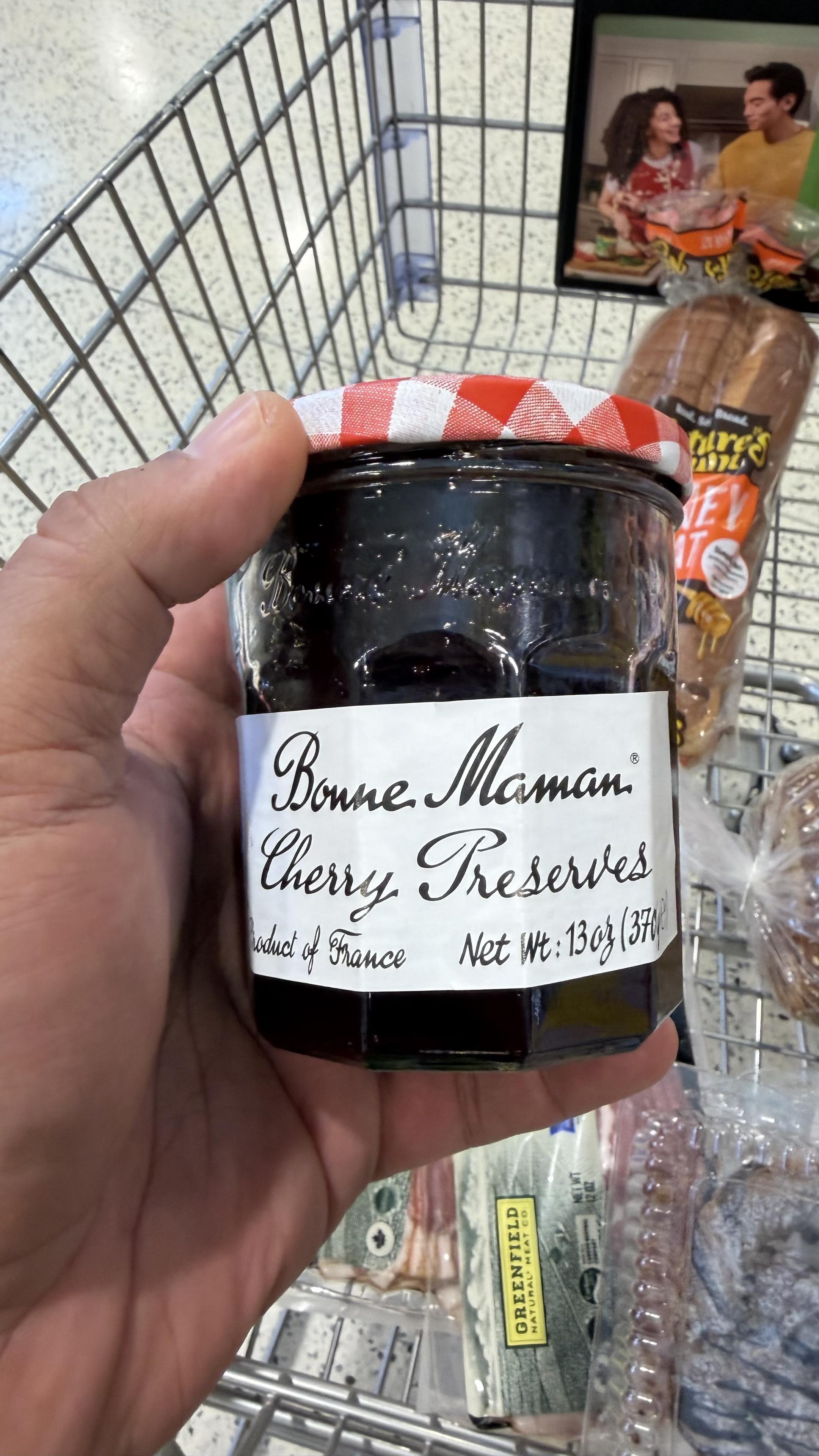 My Hand holding a jar of cherry preserves
