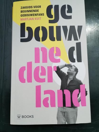 De vocer van  "Gebouwd Nederland - zakgids voor beginnende gebouwenfans. Met de auteur die omhoog kijkt.