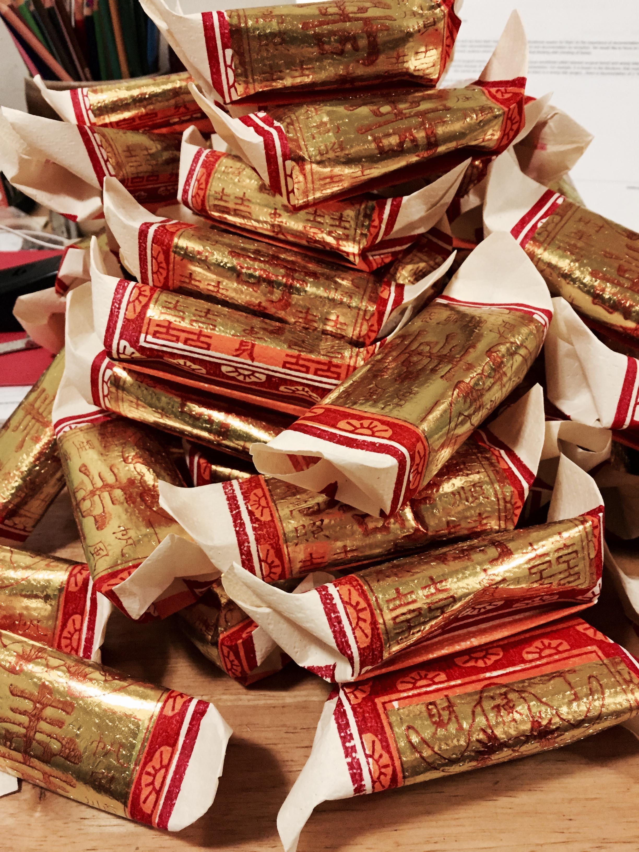 folded origami paper covered in gold paint and Chinese characters