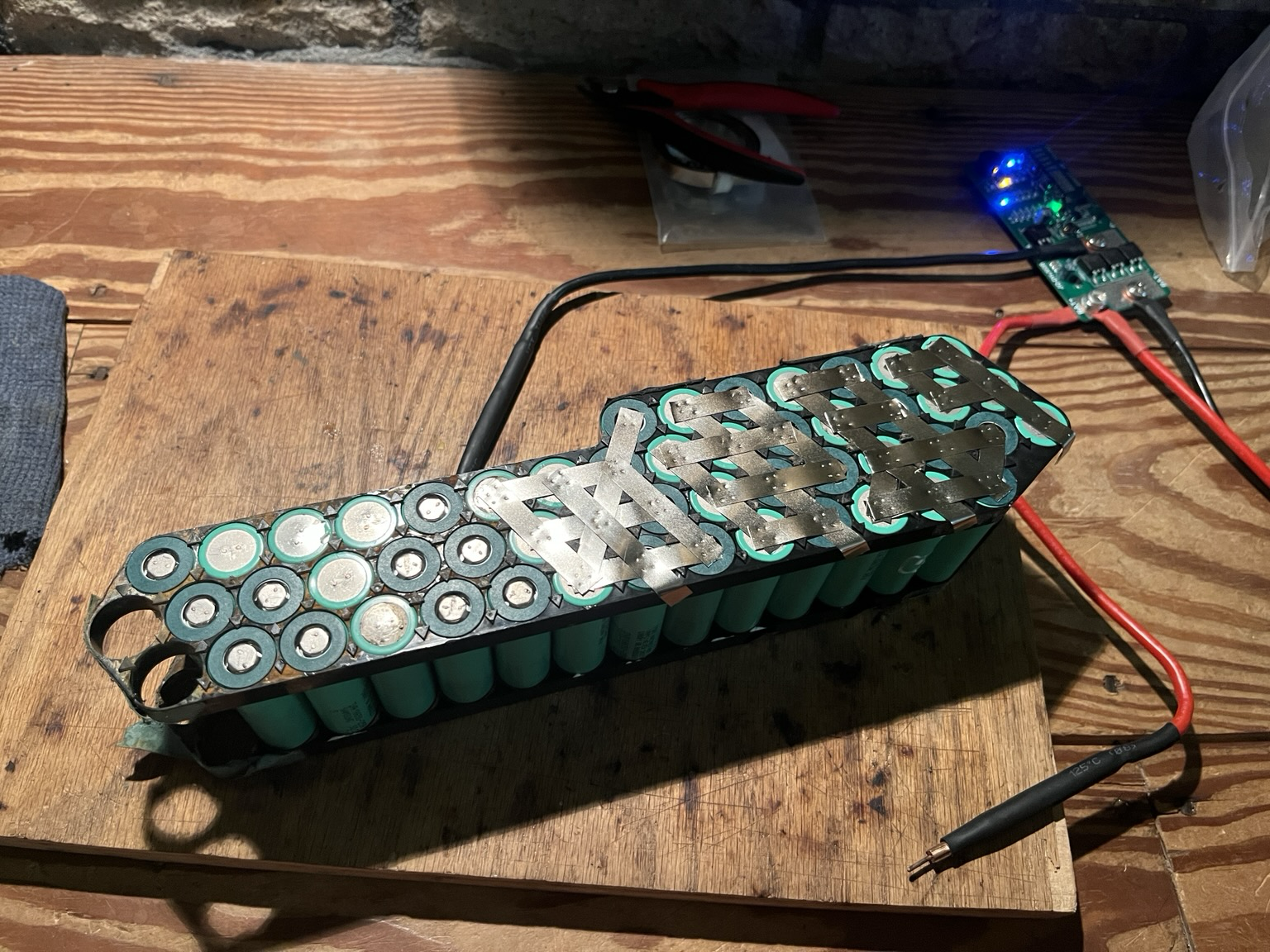 18650 cells in holders for a down tube pack configured for 10 groups of 5 cells with nickel strips welded to 7 of the groups and a spot welder laying beside the pack