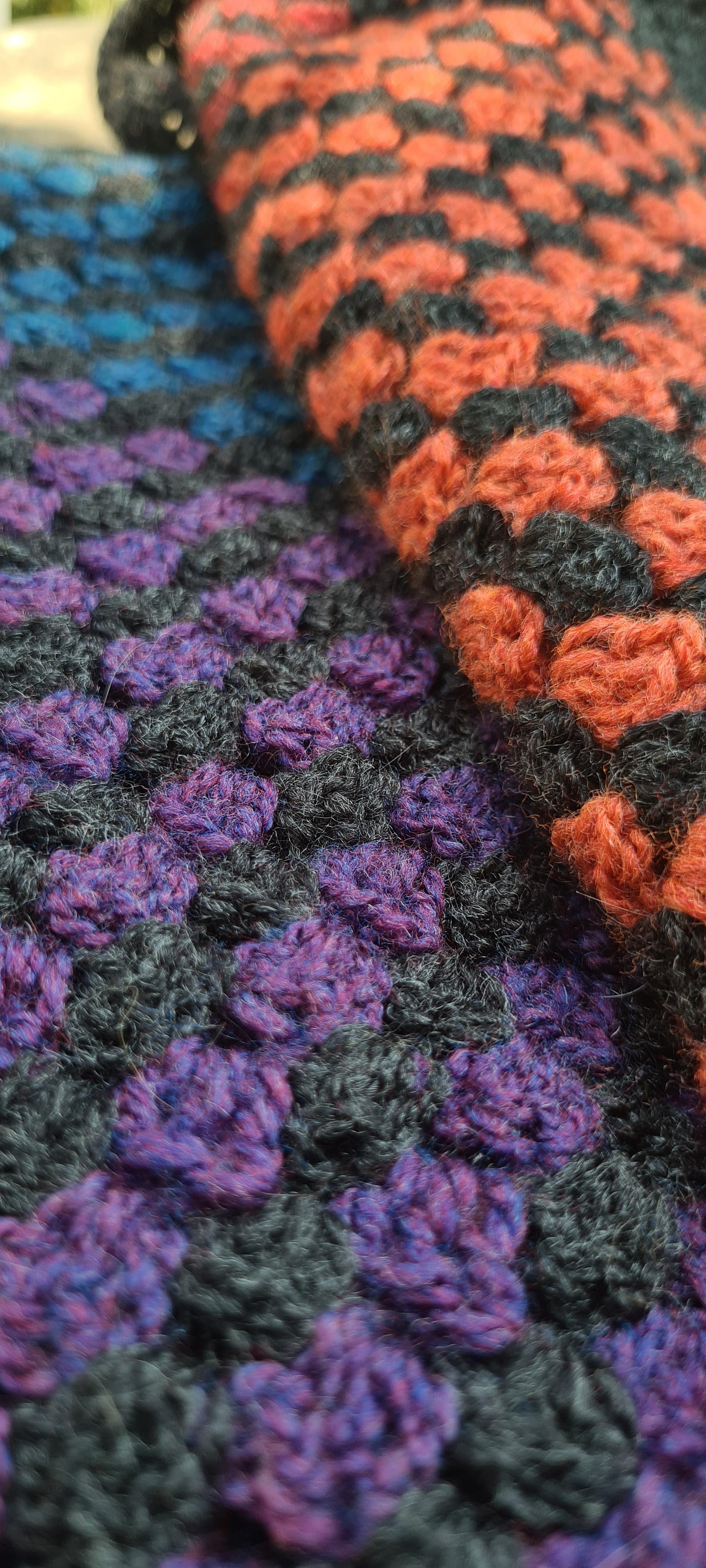 An actual close up of the blanket, now folded up, to better show the charcoal lines in-between the colours.