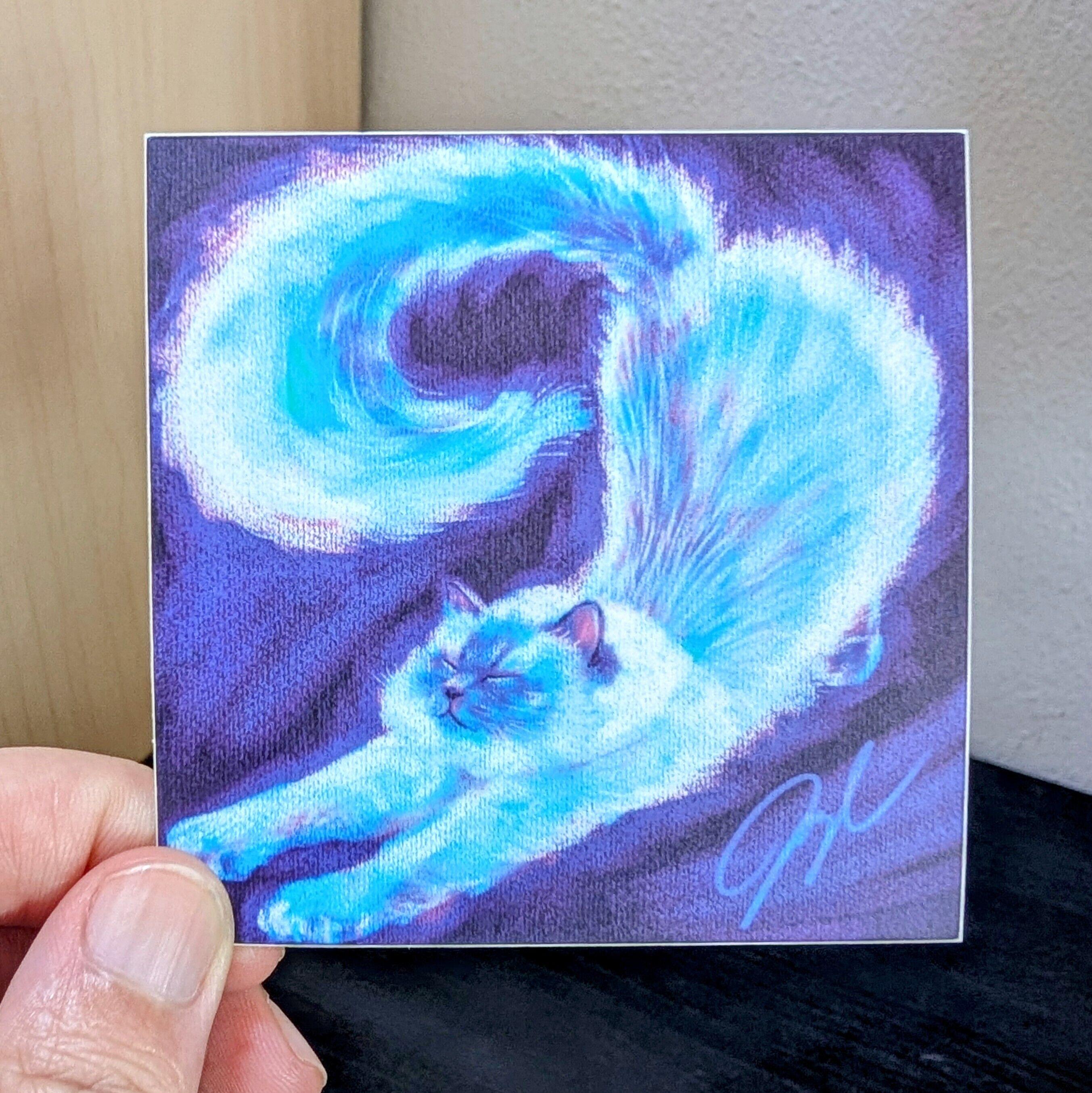 Photo of a left hand holding a square sticker. The sticker is a matte painting of a Siamese cat stretching.