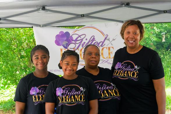 Four black people weaaring black shirts that read Gifted Elegance