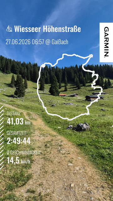This image is a Garmin Connect summary of a cycling activity titled "Wiesseer Höhenstraße", completed on June 27, 2026, at 06:57 in Gaißach. Here are the key details of the ride:
- Distance: 41.03 kilometers
- Total Time: 2 hours, 49 minutes, and 44 seconds
- Average Speed: 14.5 km/h
The image features a scenic background of a lush, green mountainous landscape with dense forests and a winding trail. The route trace is overlaid on the image, showing the path taken during the ride. The Garmin log…