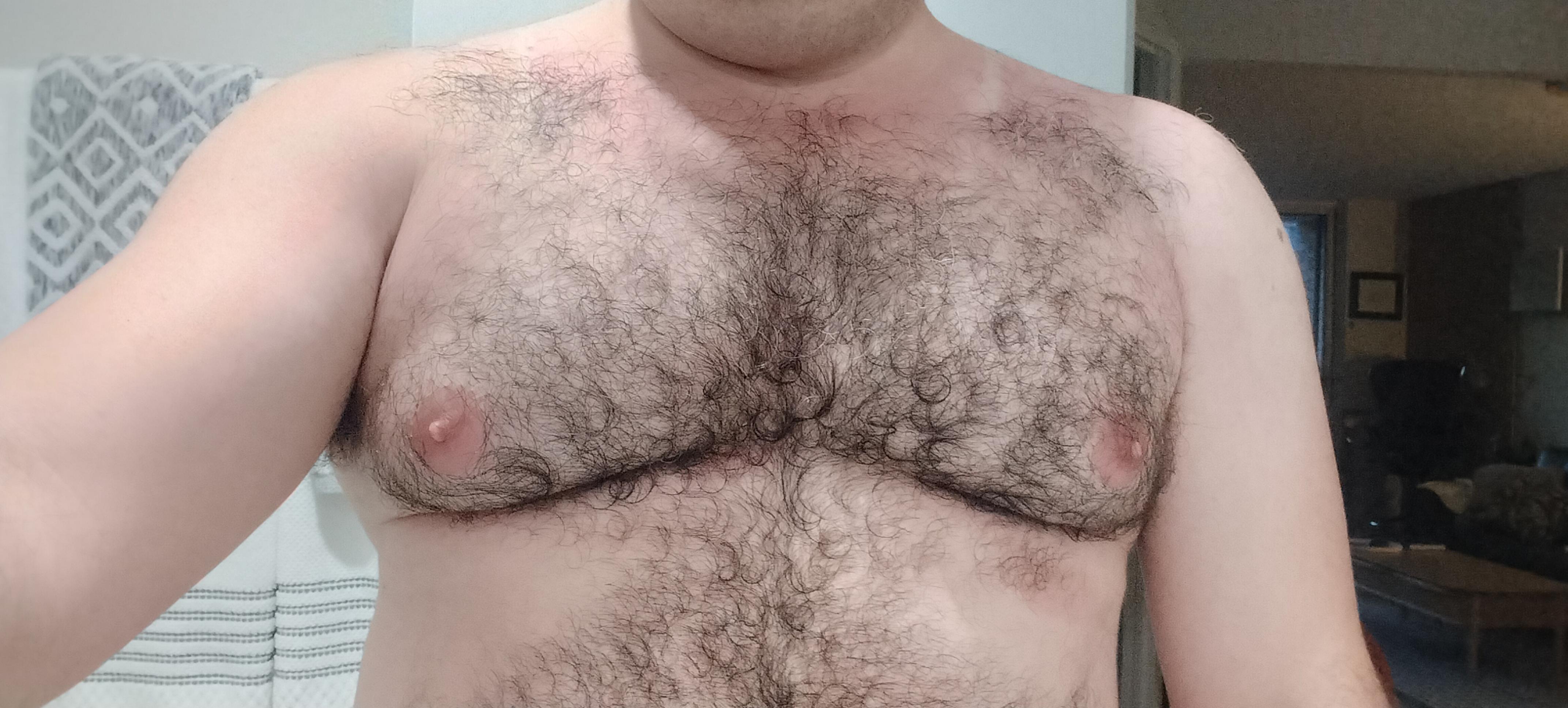 My bare chest with red marks around the shoulders expect where there are white lines that would match a stringer tank top.