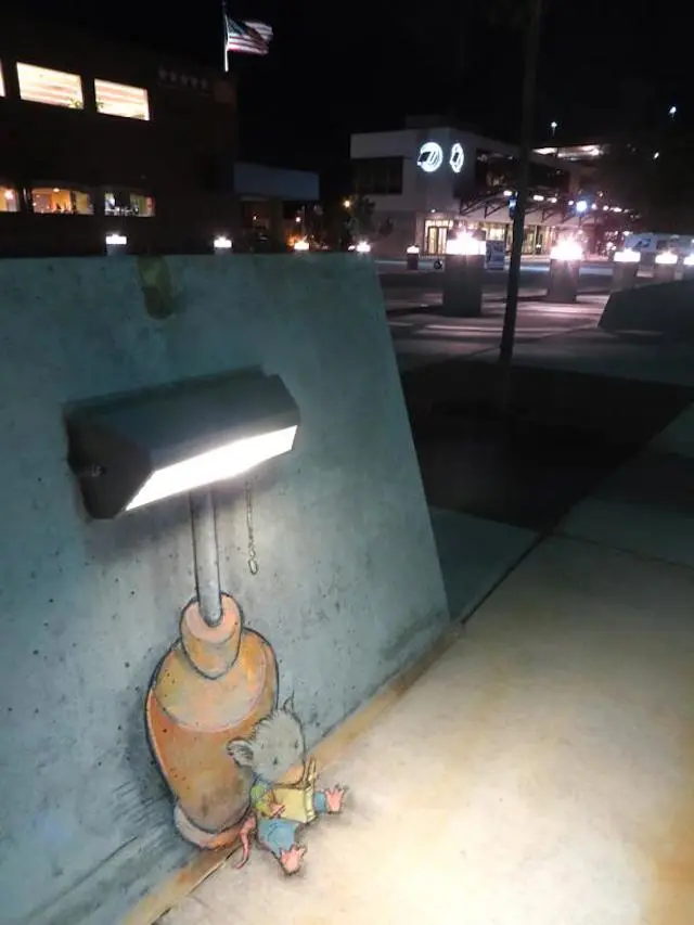 Bereitgestellt von @altbot, privat und lokal generiert mit Gemma4:26b
―
Ein nächtliches Stadtbild mit einer grauen Betonwand und einer kleinen Illustration im Vordergrund. Eine dunkle Lampe ist an der Wand montiert und strahlt Licht nach unten ab. Am Fuß des Lampenpfosts sitzt eine kleine, kleine, handgezeichnete Figur mit großen Ohren und liest ein aufgeschlagenes Buch. Der Hintergrund zeigt eine nächtliche Stadtlandschaft mit beleuchteten Fenstern in Gebäuden, hellen Pollerleuchten und einer US-Flagge oben auf einem Gebäude.