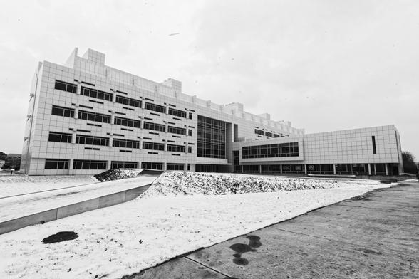 Two-pointer perspective monochrome picture of a striking white building with dark windows in the snow.