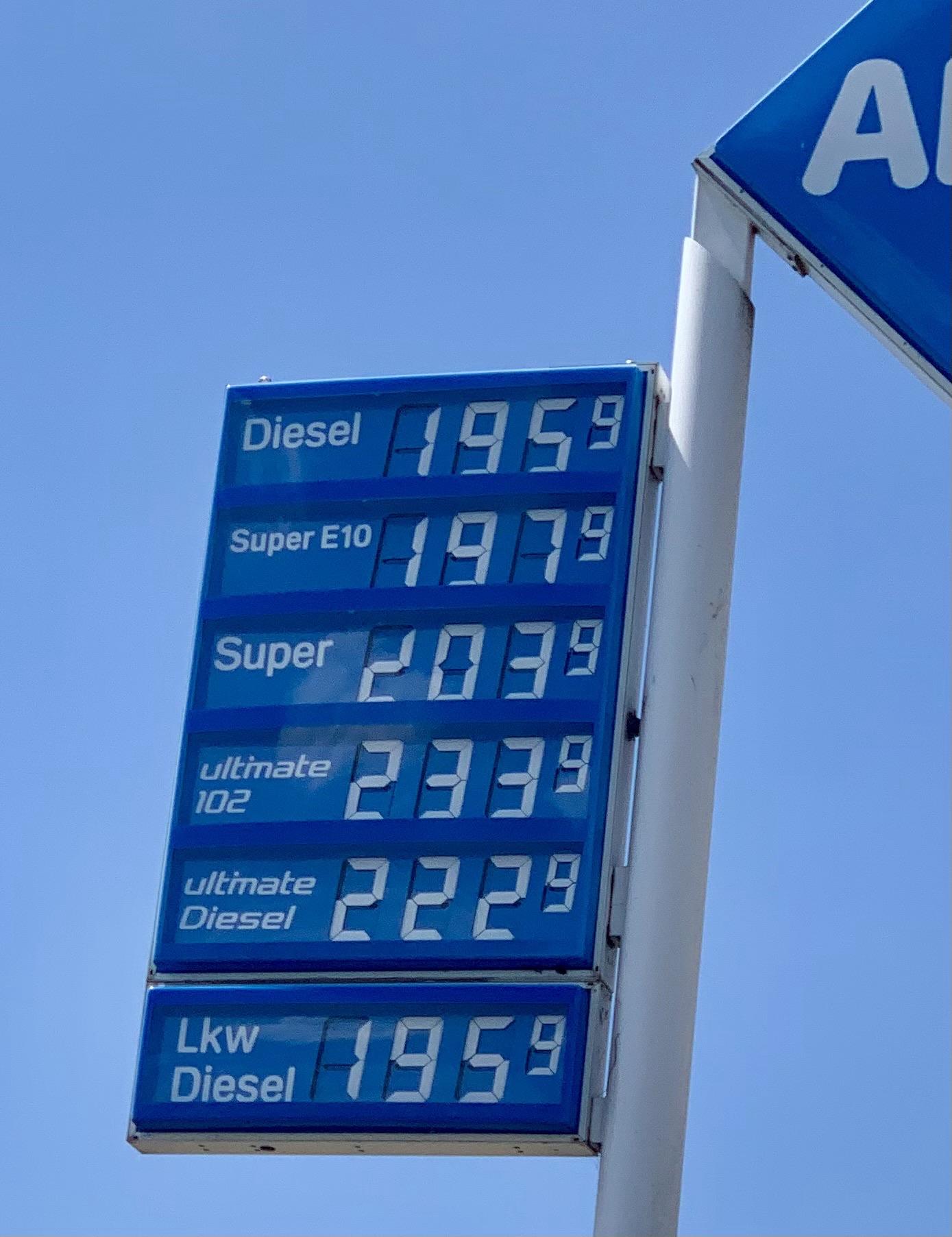 Eine Kraftstoffpreisanzeige mit Preisen für verschiedene Kraftstoffarten: Diesel bei 195,9, Super E10 bei 197,9, Super bei 203,9, Ultimate 102 bei 233,9, Ultimate Diesel bei 222,9.