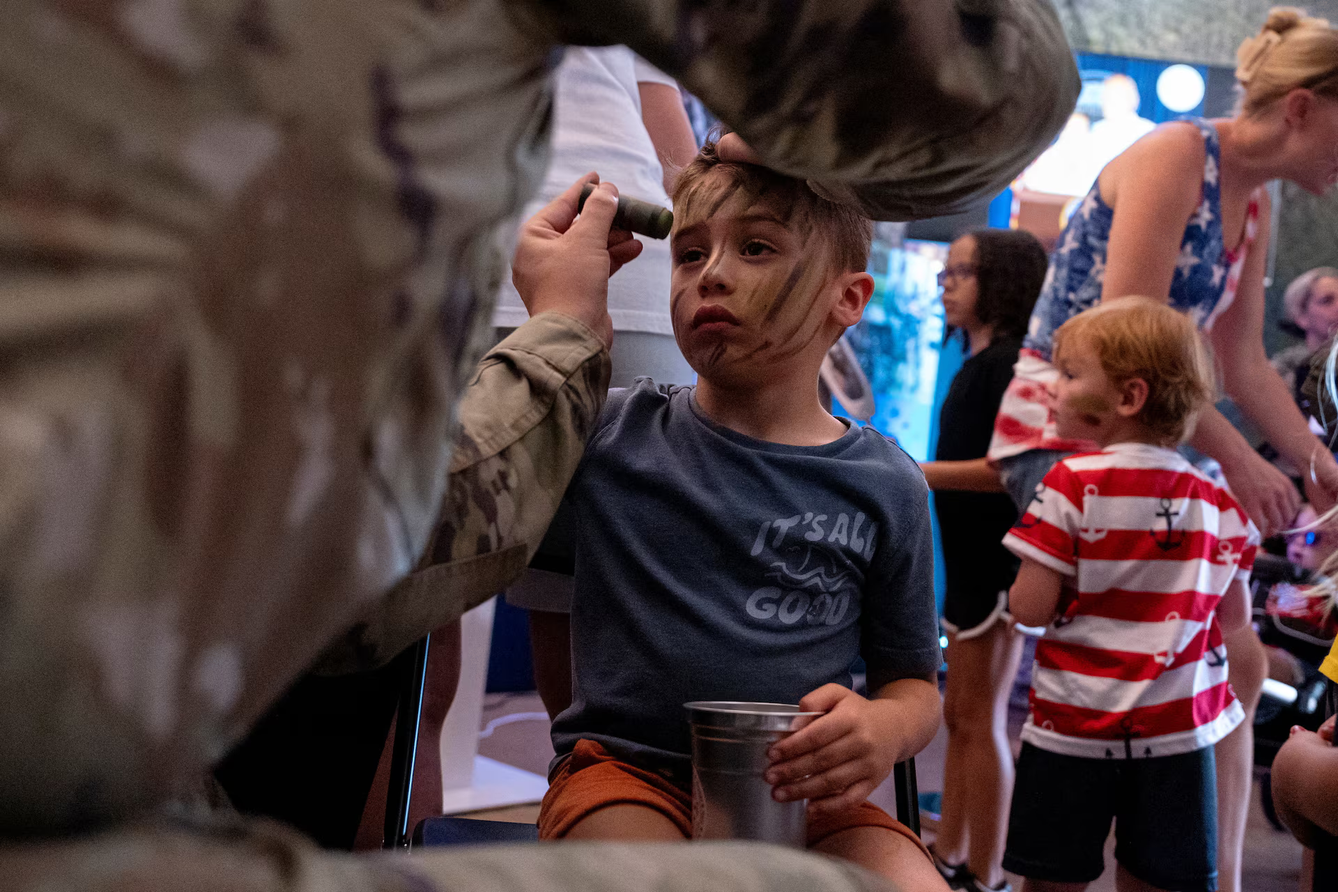 A young boy has his face painted by a service member of the U.S. Department of Defense booth at The Great American State Fair, June 29. REUTERS/Cheney Orr