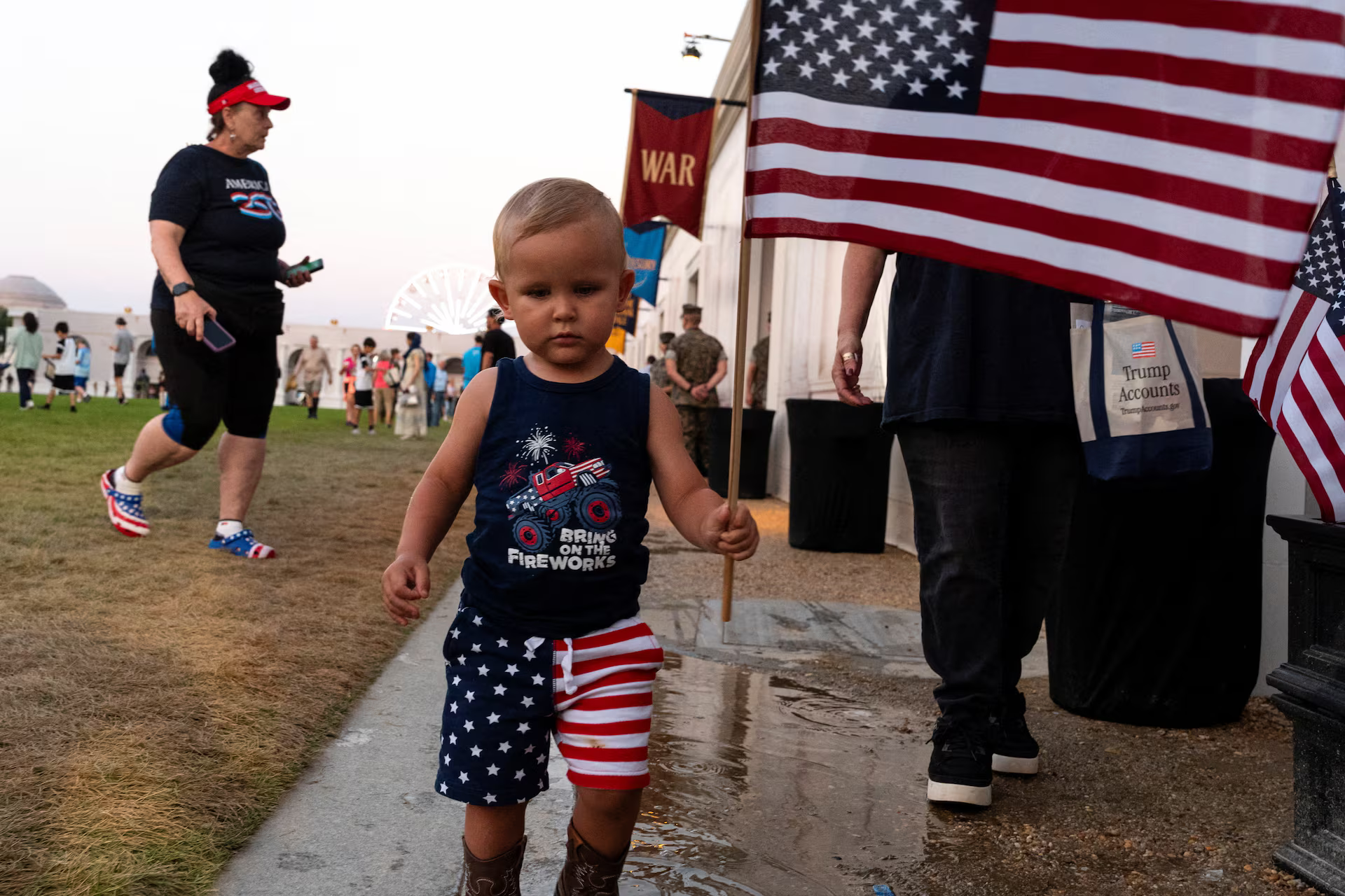 A young boy carries a U.S. flag past the U.S. Department of Defense booth at The Great American State Fair, June 29. .REUTERS/Cheney Orr