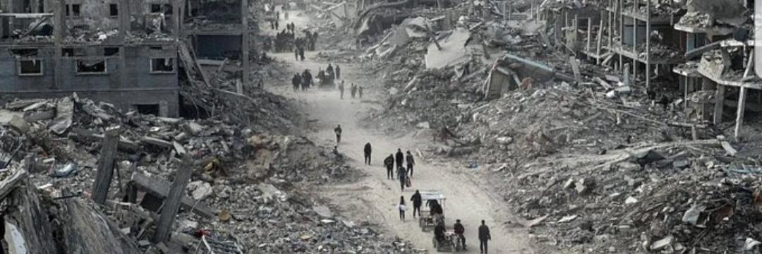 A scene from Gaza showing widespread destruction, with damaged buildings and debris covering the area. The image reflects the devastating impact of armed conflict on civilian neighborhoods. It accompanies a post explaining the difference between Human Rights and International Humanitarian Law, highlighting the protection of civilians during war. The post also shares that my family is living through these conditions and invites readers who are able to support or share our fundraising campaign