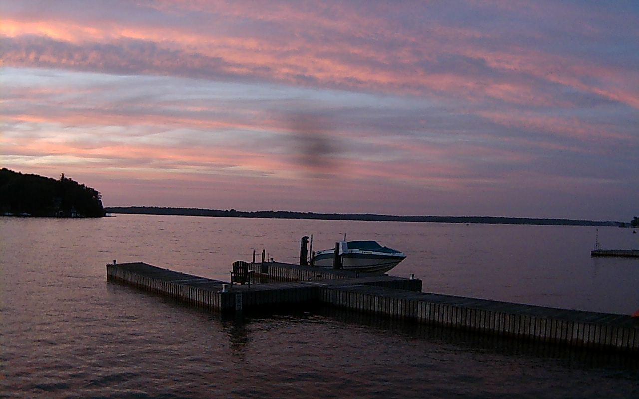 Northern view from The Stitchery overlooking a small forked pier on the shores of the St. Lawrence River near where it meets Lake Ontario. // Image captured at: 2026-07-05 01:00:06 UTC (about 1 min. prior to this post) // Image sourced from: 1000islandswebcams.com // Current Temp in Clayton: 69 F | 21 C // Precip: few clouds // Wind: ENE at 3 mph | 5 kph // Humidity: 81%