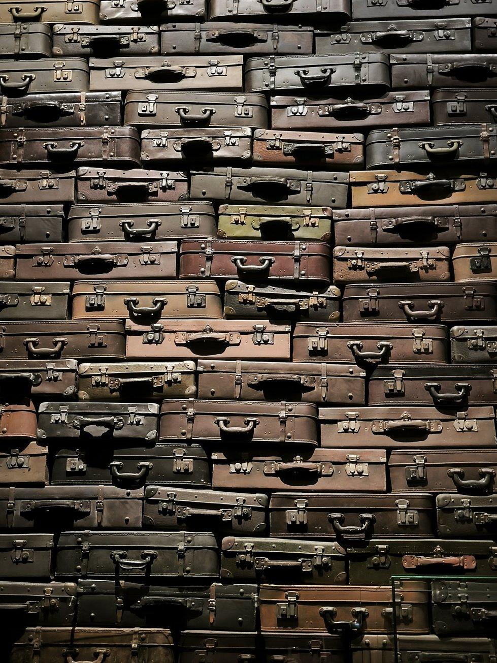 Eine Ganze Wand bis an die die Decker gestapelte alte Koffer