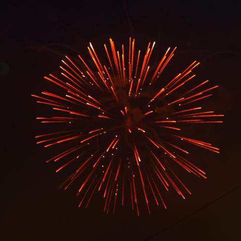 Wound firework burst with white points trailing orange expanding from a central point with a few white dots flloating in the middle.