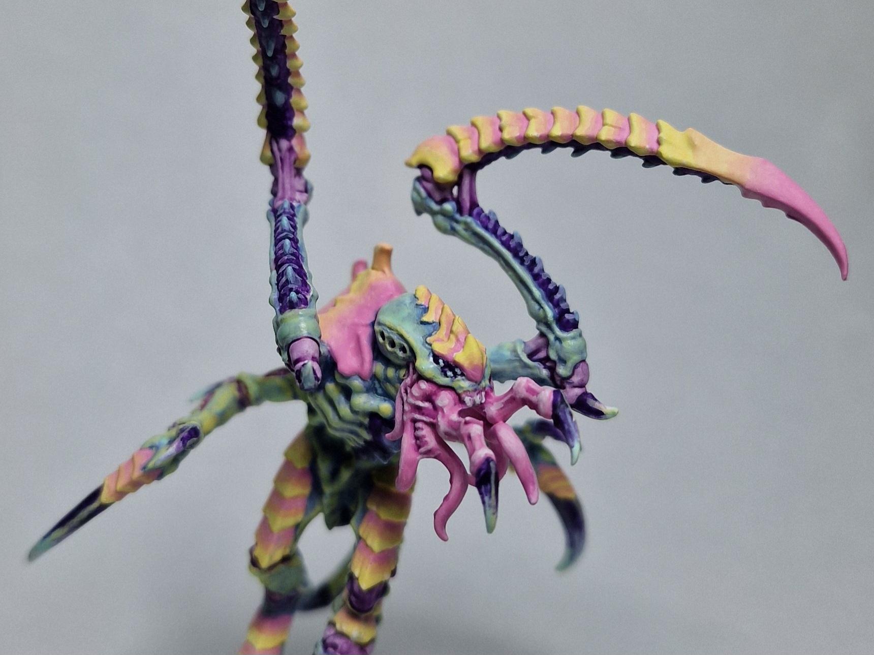 Miniatura de Warhammer, Saltador de Von Ryan, pintada en tons pastel (rosa, groc, lila i verd menta), fotografiada sobre fons blanc. Tirànid amb dues llargues pinces corbades i una boca plena de tentacles.