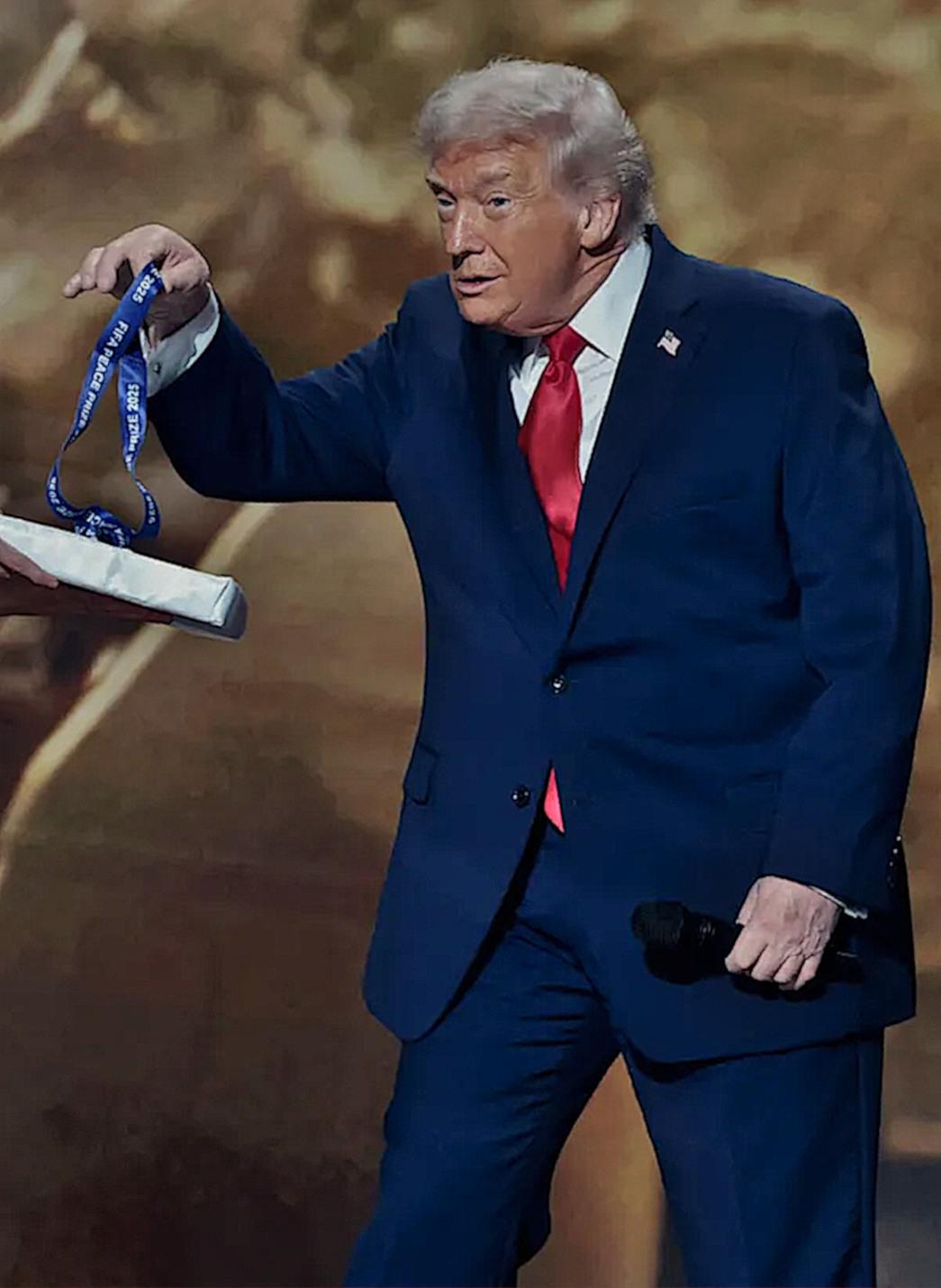 Trump receives a medalion from Infantino at the World Cup draw, where he  also received a "Peace Prize"