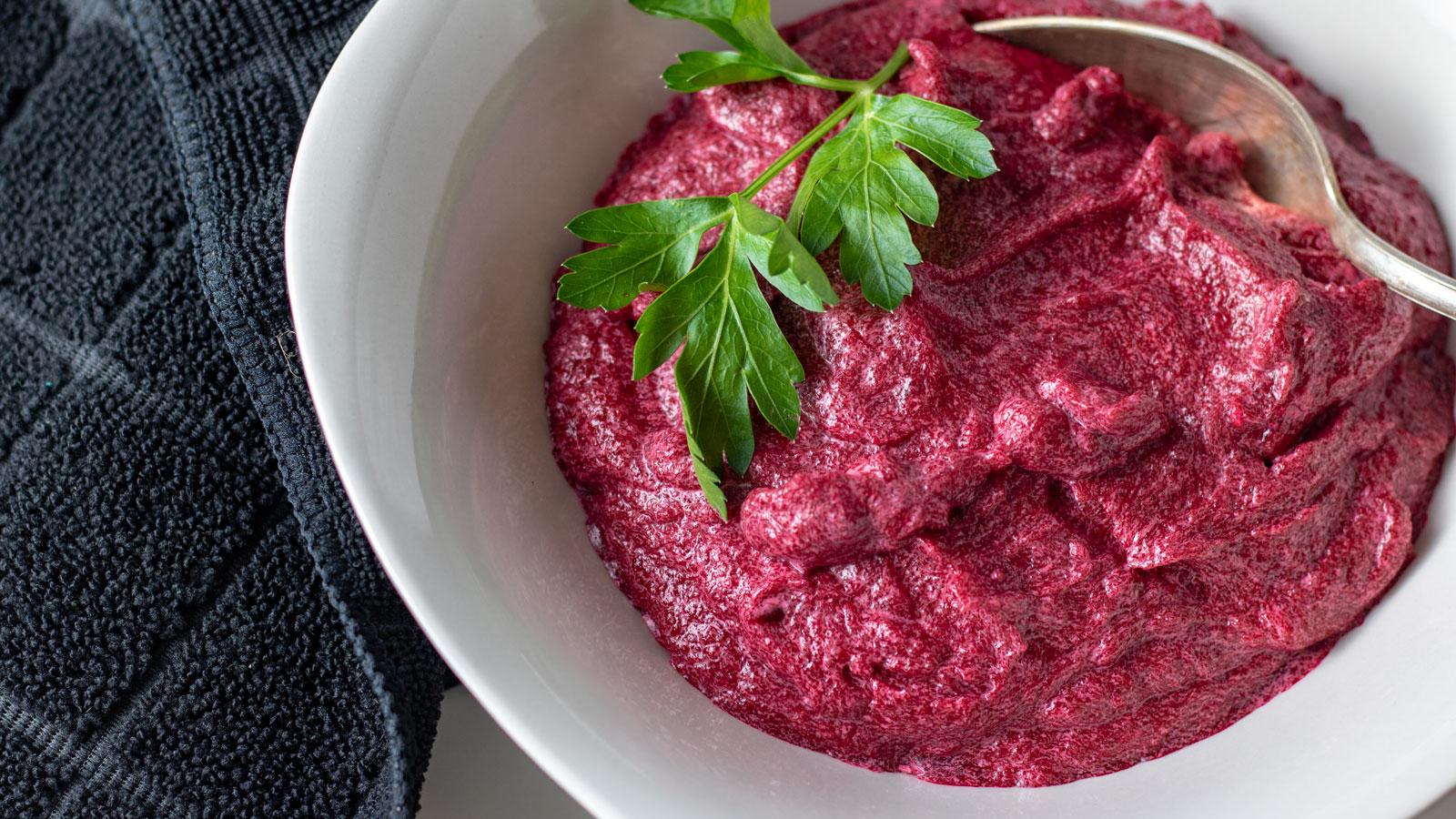 Smooth beet purée in a white bowl with deep red hue