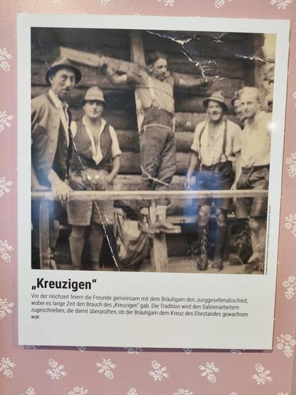 Infotafel im Stadtmuseum Bad Ischl, die den bei Junggesellenabschieden betriebenen Brauch des Kreuzigens beschreibt, samt einschlägigem Foto.
