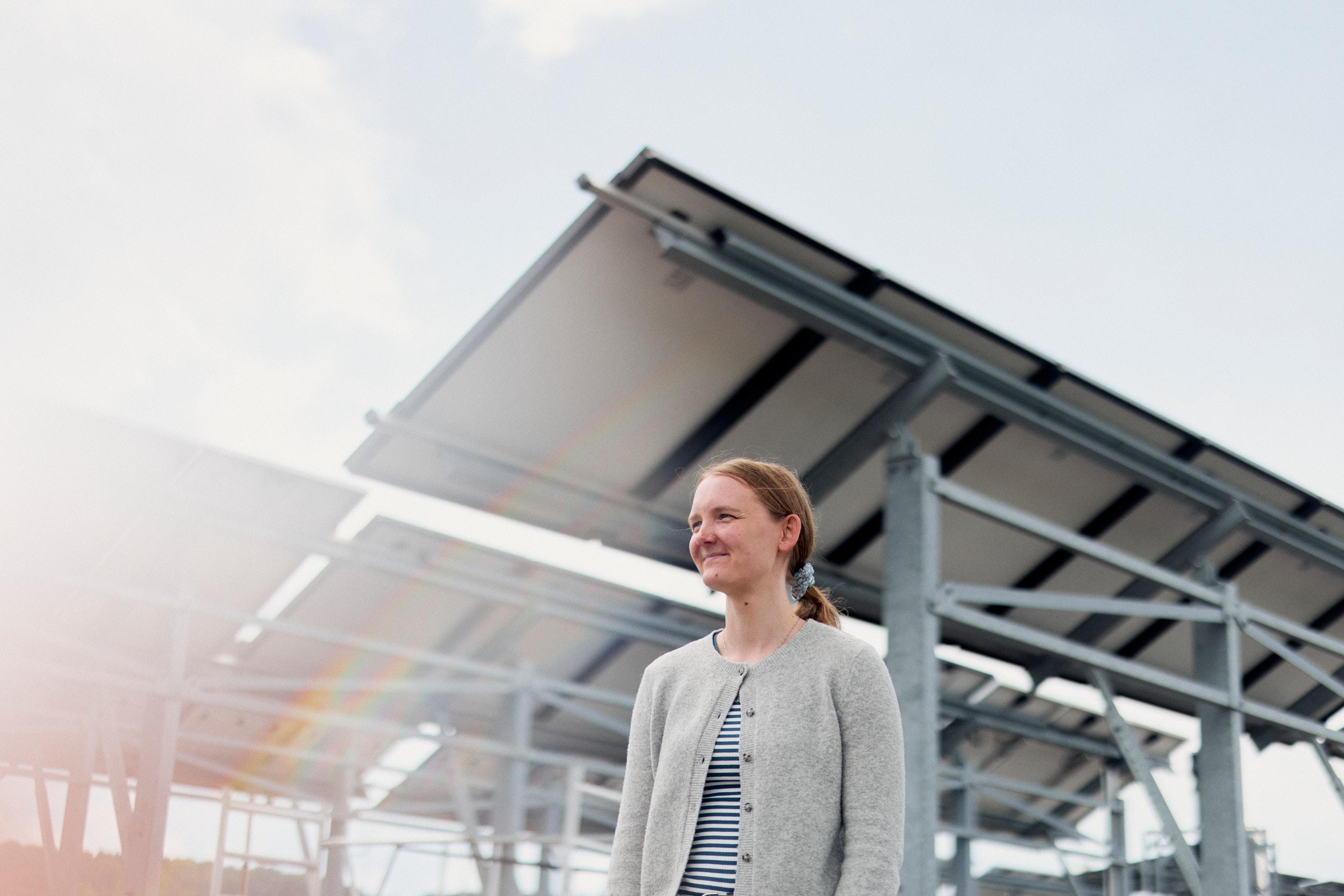 Katharina Schnatmann steht auf dem Dach der HSBI, im Hintergrund sind Photovoltaik-Anlagen zu sehen