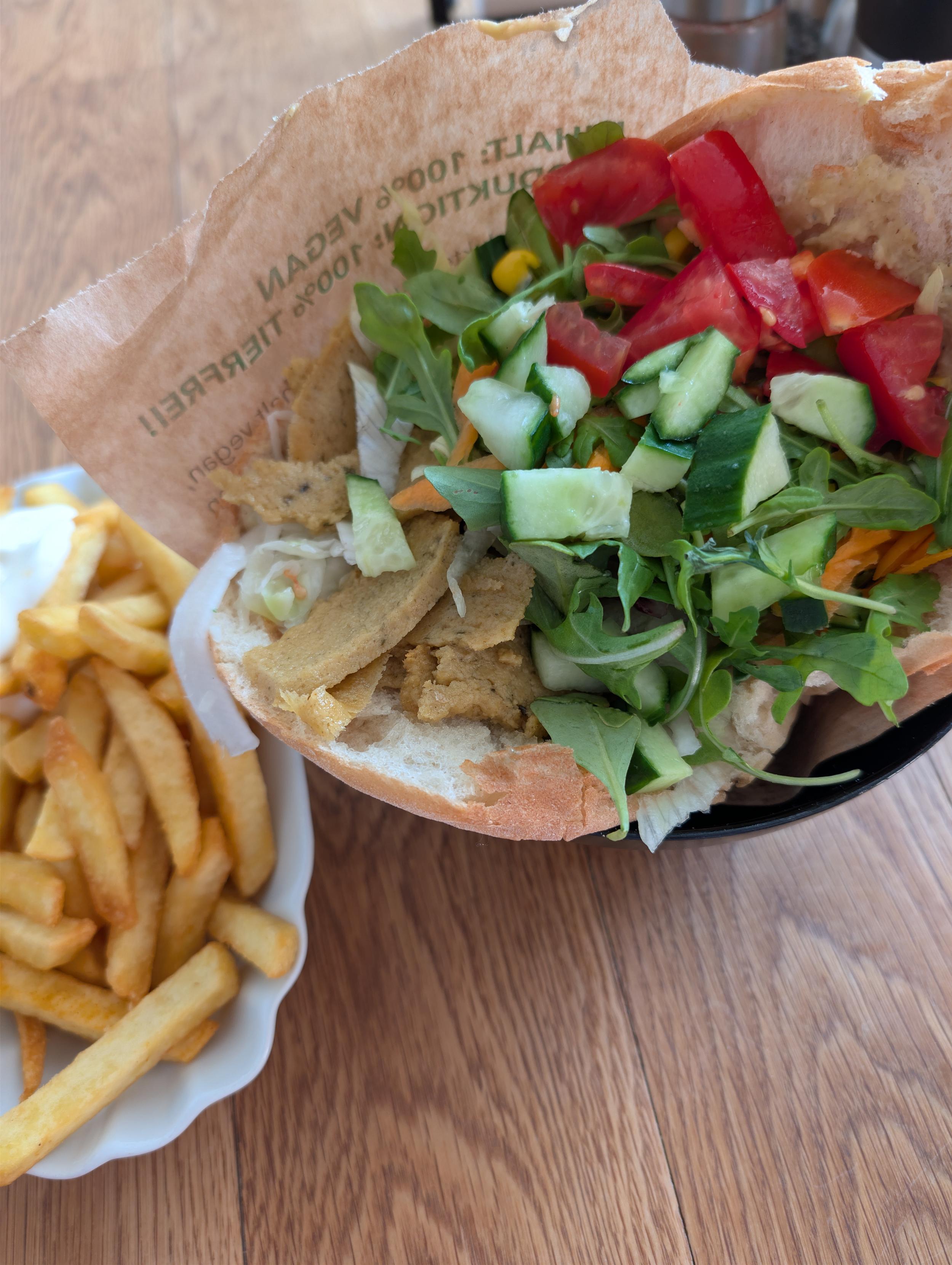 Ein sehr bunter, frischer Döner mit Seitan und viel Gemüse und eine Portion Pommes mit Majo (alles vegan)